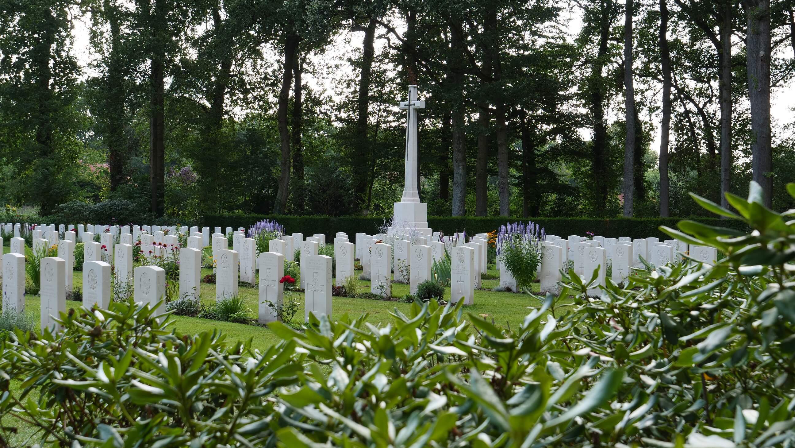 Headstones and cross of sacrifice in Arnhem Oosterbeek War Cemetery, The Netherlands