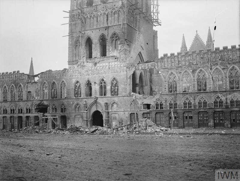 Ypres Cloth Hall showing the damage it sustained during the First Battle of Ypres. The ornate medieval building has been turned to rubble in places though the main rectangular building and bell tower still stand.