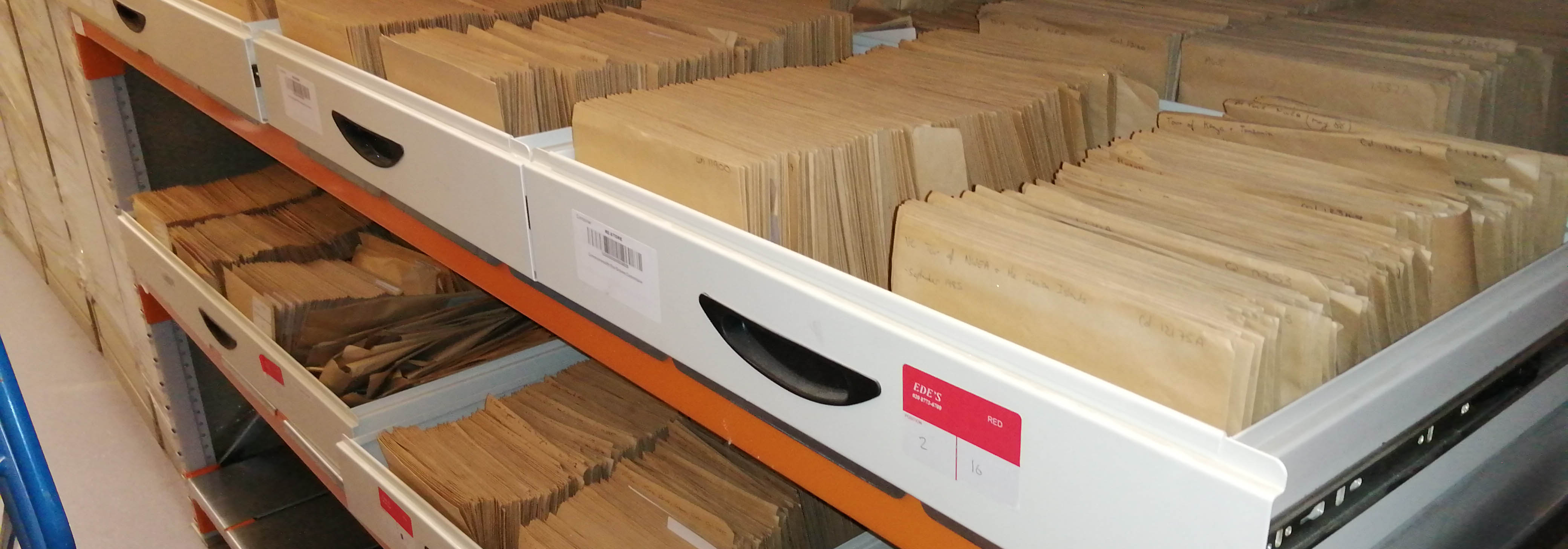 Draws of documents kept in brown envelopes in a storage facility.