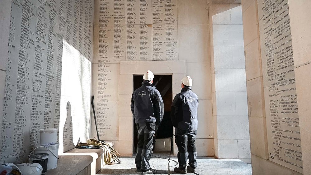 Workmen examining damaged name panels and masonry at the Menin Gate Memorial.