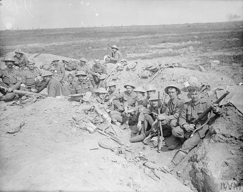 Welsh Guardsmen sitting in a trench on the WW1 battlefield of the Somme.