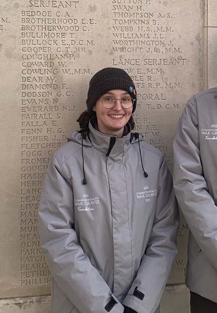 Beth Crichton, Commonwealth War Graves Guide, posing in front of memorial panels.